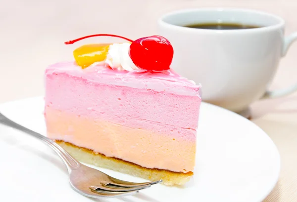 Piece of cream cake with cherry on plate — Stock Photo, Image