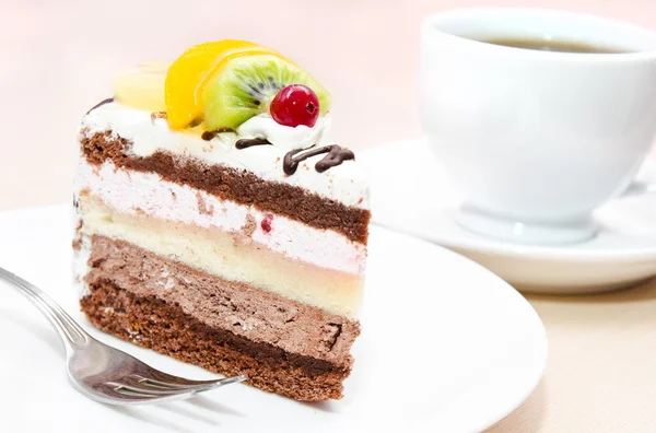 Stuk van chocolate cake met vruchten op plaat — Stockfoto