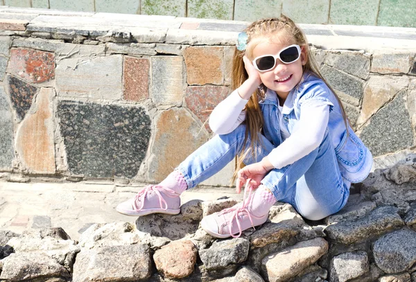 Adorável menina sentada em pedras — Fotografia de Stock