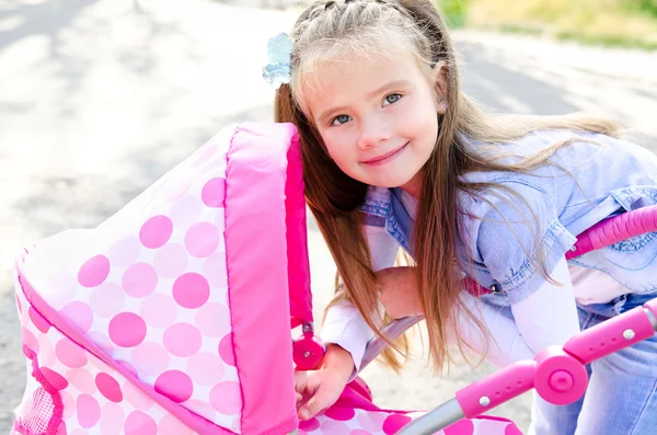 Petite fille souriante mignonne jouant avec son chariot de jouet — Photo