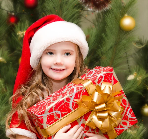 Santa şapka hediye kutusu ile sevimli gülümseyen küçük kız