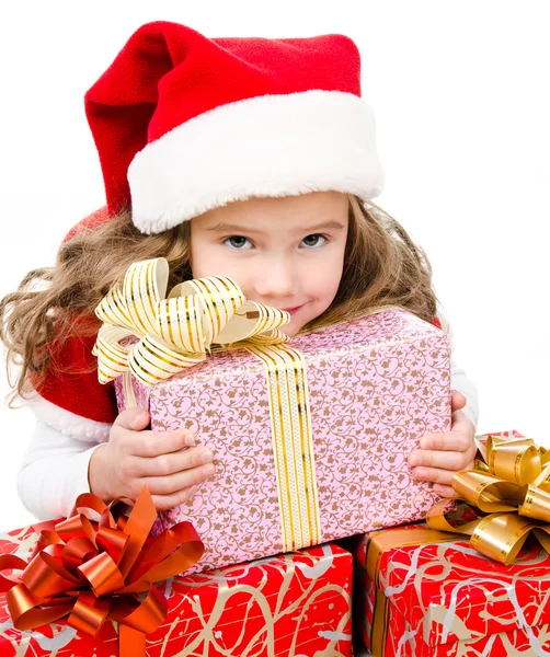 Happy cute little girl with christmas gift boxes and santa hat — Stock Photo, Image