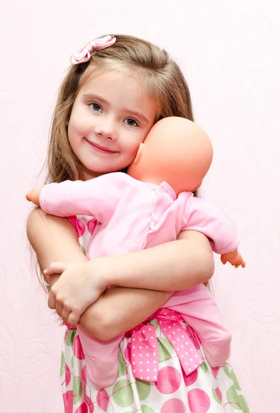 Linda niña sosteniendo y abrazando su muñeca — Foto de Stock