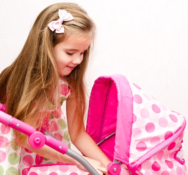 Schattig lachende klein meisje spelen met haar speelgoed vervoer en doll — Stockfoto