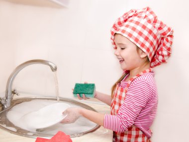Sevimli gülümseyen küçük kız bulaşıkları yıkama