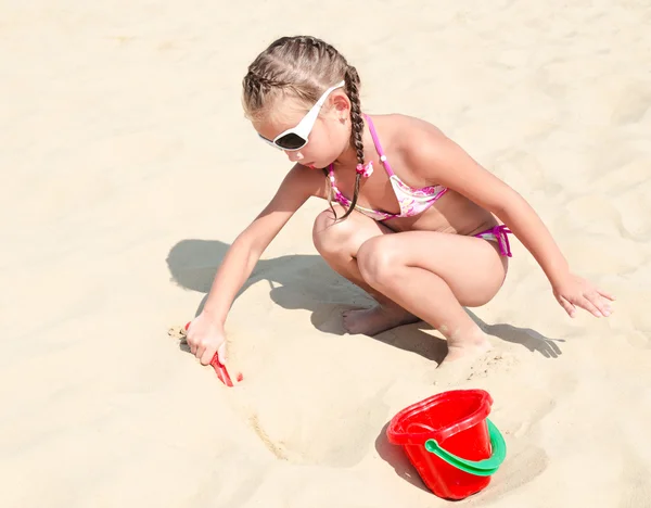 Carino sorridente bambina che gioca sulla spiaggia — Foto Stock