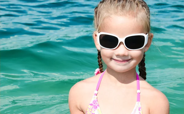Bedårande leende liten flicka på strandsemester — Stockfoto
