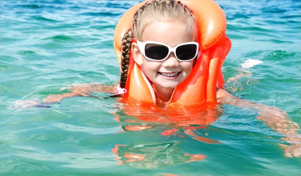 Úszás-a mentőmellény mosolygós kislány — Stock Fotó