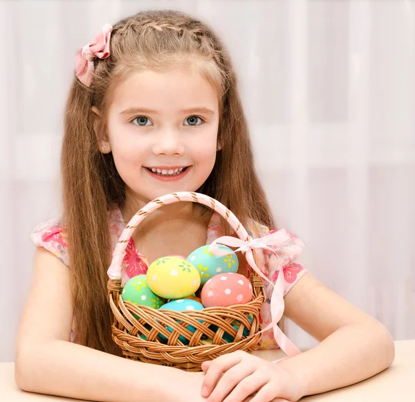 Carino sorridente bambina con cesto pieno di uova di Pasqua — Foto Stock