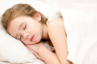 Yatakta uyuyan sevimli küçük kız 