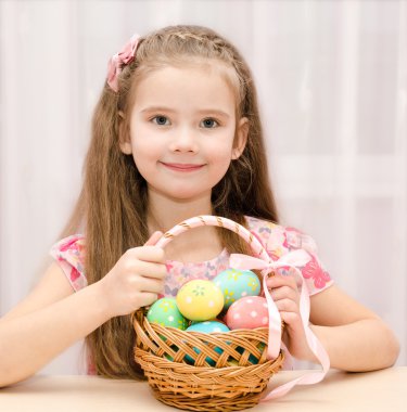 sepet renkli Paskalya yumurtaları dolu küçük kız gülümseyerek