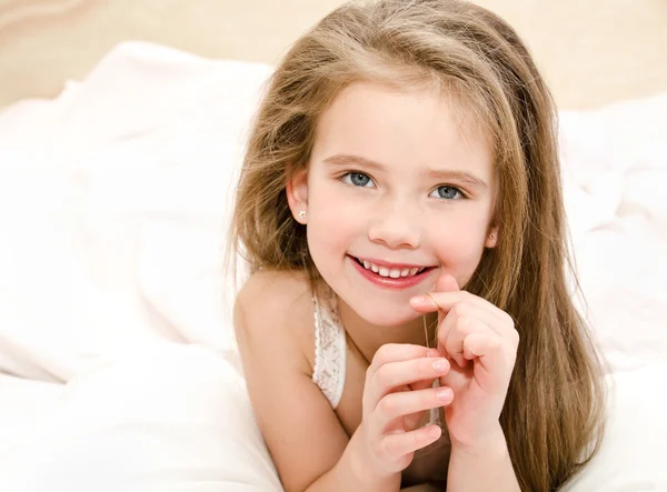 Очаровательная улыбающаяся маленькая девочка проснулась — стоковое фото