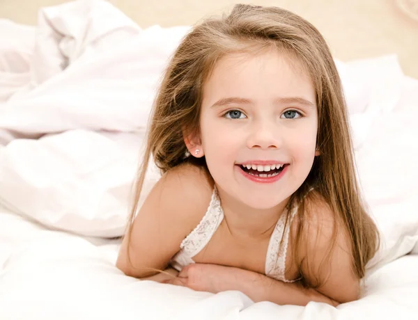 Чарівна усміхнена маленька дівчинка прокинулася — стокове фото
