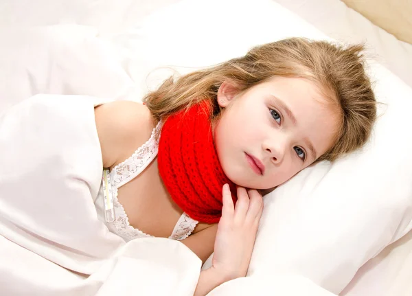 Little girl lying in the bed with thermometer — Stock Photo, Image