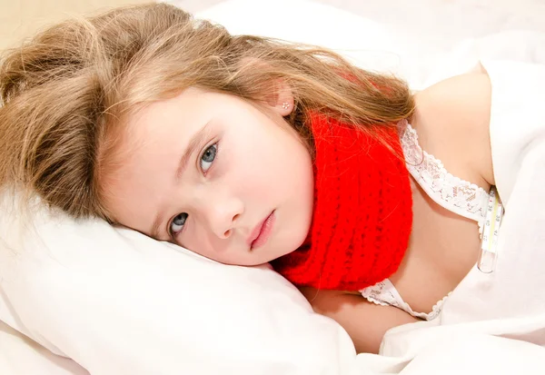 Little girl lying in the bed with thermometer — Stock Photo, Image