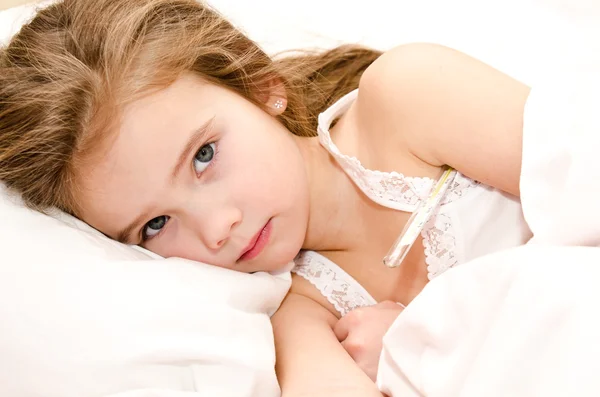 Niña enferma acostada en la cama — Foto de Stock