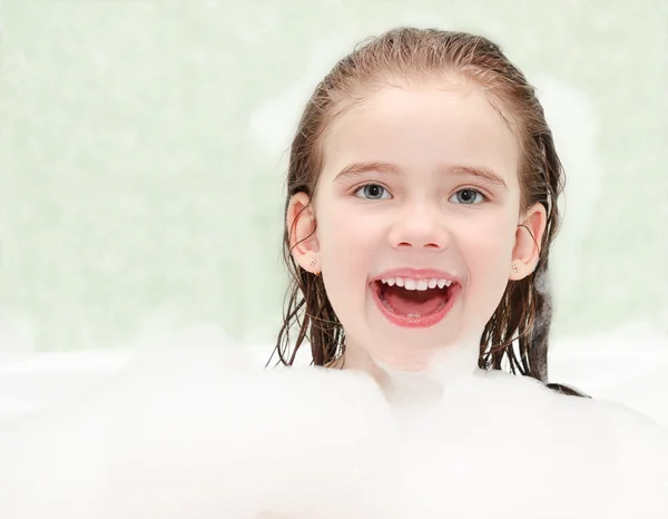 Happy little girl washing in bath — Stock Photo, Image