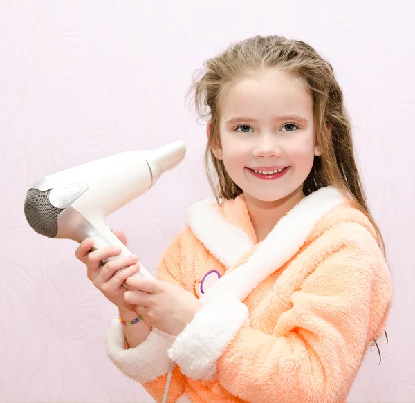 Cute smiling little girl dries hair — Stock Photo, Image
