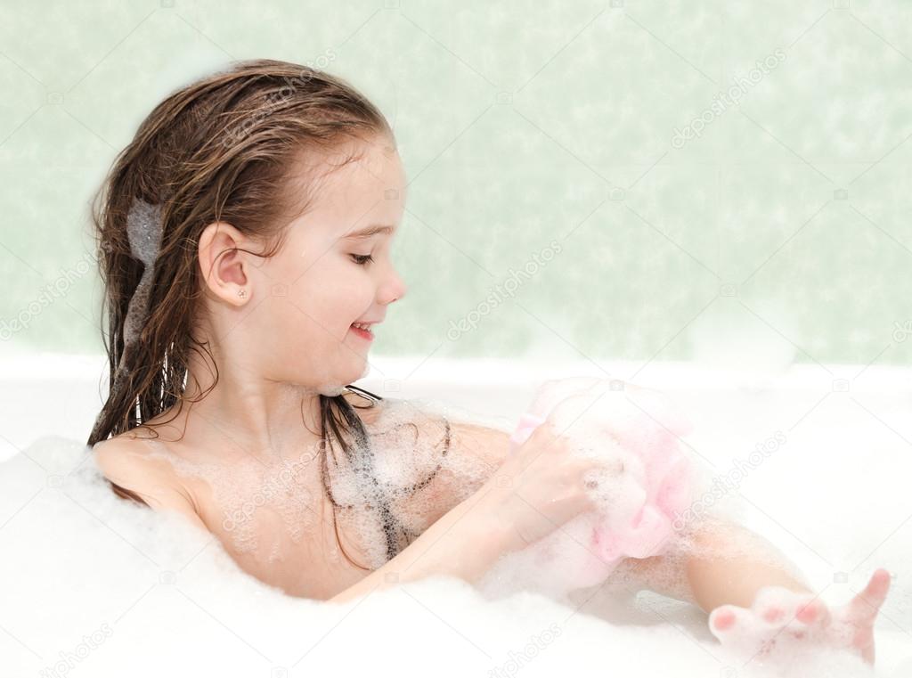 Smiling little girl washing in bath