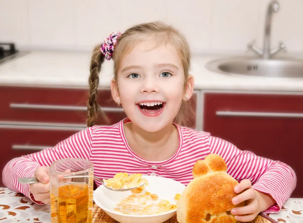 Cute smiling little girl having breakfast cereals with milk — Stock Photo, Image