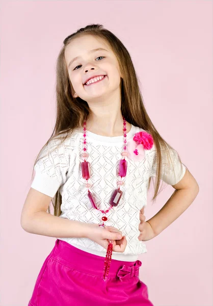 Cute smiling little girl in skirt and beads — Stock Photo, Image