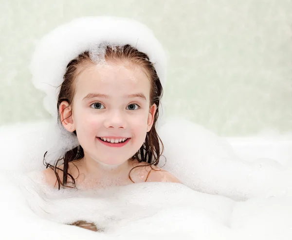 Smiling little girl washing in bath — Stock Photo, Image