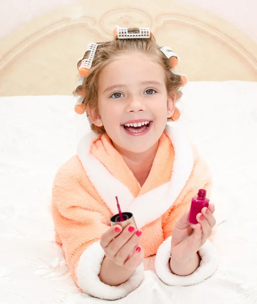 Happy funny little girl polishing her nails — Stock Photo, Image