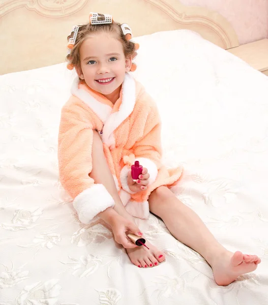 Happy funny little girl polishing her nails — Stock Photo, Image