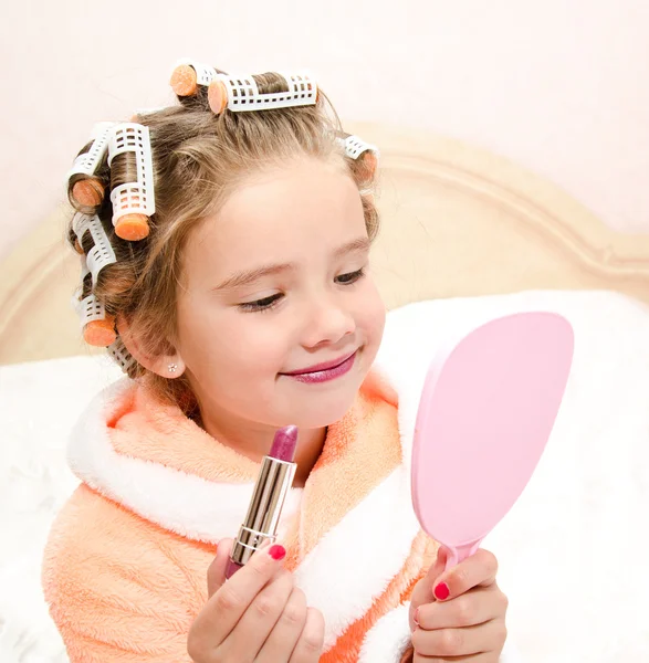 Schattig klein meisje met lippenstift en spiegel — Stockfoto