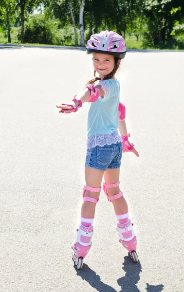 ピンクのローラー スケートでかわいい笑顔女の子 — ストック写真