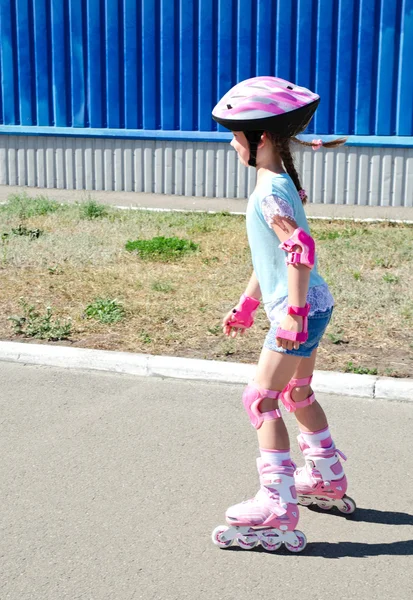 Carino sorridente bambina in pattini a rotelle rosa — Foto Stock