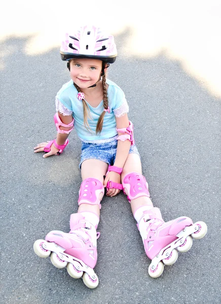 Jolie petite fille souriante en patins à roulettes roses — Photo