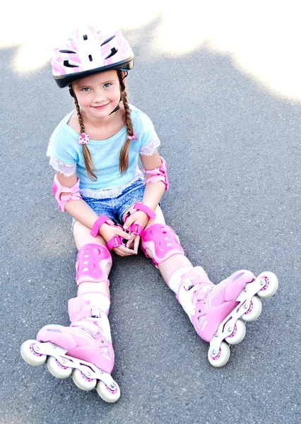 Carino sorridente bambina in pattini a rotelle rosa — Foto Stock