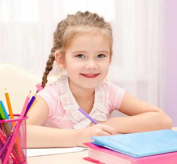 Carina bambina sta scrivendo alla scrivania — Foto Stock