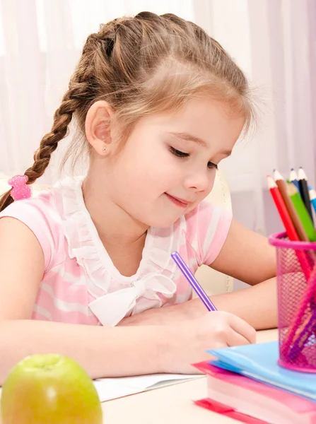 Is het schrijven van schattig klein meisje aan de balie — Stockfoto