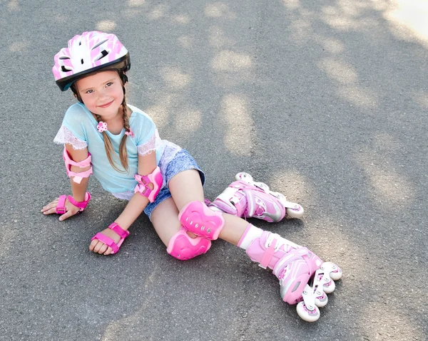 Söta leende liten flicka i rosa rullskridskor — Stockfoto