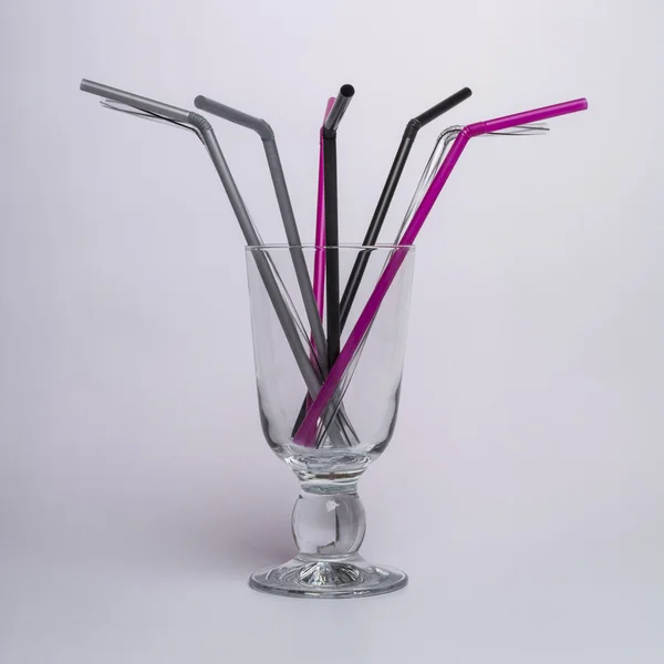 Tubes for cocktails in a crystal wineglass — Stock Photo, Image