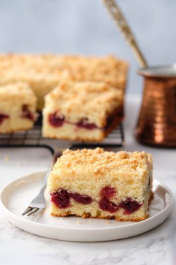 Beyaz arka planda pişmiş kare kirazlı turta yığını. Kirazlı ekşi kremalı kahveli kek..