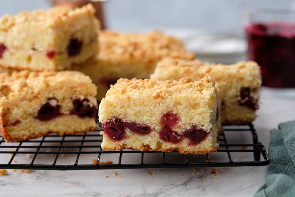 Una pila de trozos cuadrados horneados de pastel de cereza sobre un fondo blanco. — Foto de Stock