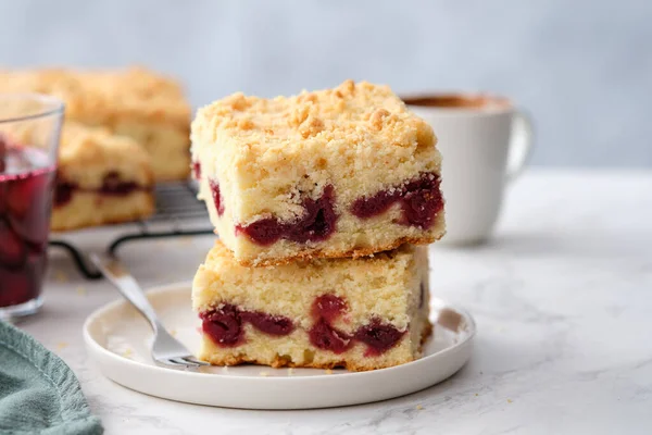 Una pila de trozos cuadrados horneados de pastel de cereza sobre un fondo blanco. — Foto de Stock