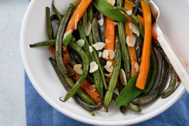 Zeytin yağı ve adaçayı ile pişirilmiş havuçlu yeşil fasulye. Sağlıklı yemek..