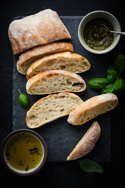 Mediterrán nasi beállítva. Olajbogyó, olaj, gyógynövények és szeletelt ciabatta kenyér. Felülnézet. — Stock Fotó