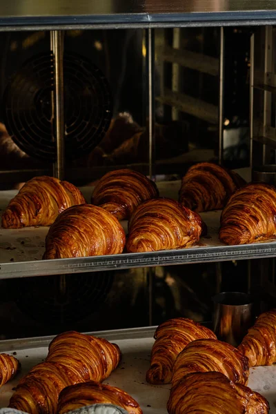 Närbild av franska läckra croissanter på hyllorna i bageri. Utformning av processen — Stockfoto