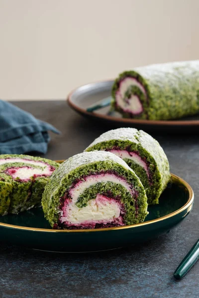 Grön spenat rulltårta med färskost och hallon fyllning på plattan. Restaurang, bageri meny eller recept koncept. Uppfattat utrymme. Jul och nyårsdessert. — Stockfoto