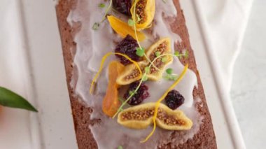 Üst Manzara. Masada roma batırılmış bir meyveli kek var. Arka planda fenerler olan bir Noel atmosferi. Ev yapımı Noel çöreği. Kurutulmuş meyveli kek. Geleneksel kek Noel için..