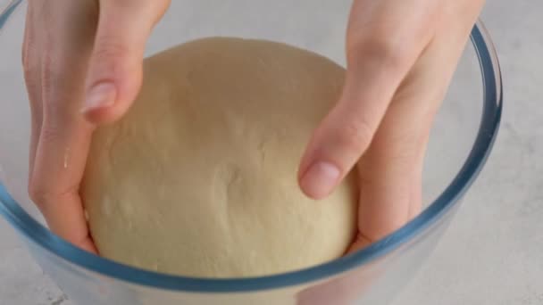 Όμορφα γυναικεία χέρια βάζουν τη ζύμη σε ένα γυάλινο μπολ σε μια επαγγελματική κουζίνα και ετοιμάζουν τη ζύμη αλεύρου για την παρασκευή ψωμιού. Ψωμί και ψωμιά. Ψωμί μαγιάς. Ψωμί από γάλα, βούτυρο, αλεύρι, αυγά και μαγιά. — Αρχείο Βίντεο