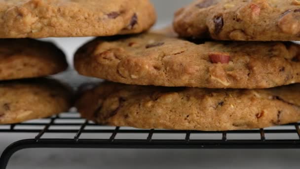 Mouvement de la caméra. Gros plan d'un biscuit aux pépites de chocolat se trouve sur le porte-fil. Une femme fait un cookie aux pépites de chocolat en 4K. Le concept de faire des biscuits aux pépites de chocolat étape par étape. — Video