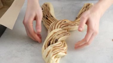 Güzel kadın elleri tarçın ve çikolatalı çörek yapmak için hamur örer. Ekmek ve ekmekler. Maya ekmeği. Süt, tereyağı, un, yumurta ve mayadan yapılmış ekmek..