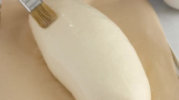 Las manos femeninas quitan la toalla de la masa sobre una mesa ligera para hacer pan de trigo. Preparamos pan blanco en una panadería profesional de harina, agua, aceite, sal. — Vídeos de Stock