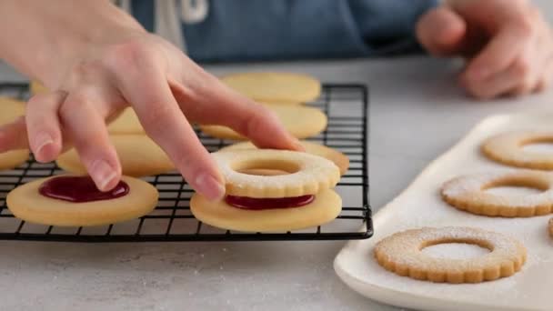 Mâinile de sex feminin au pus cookie-uri pe al doilea cookie cu gem. Mâinile unei femei fac prăjituri cu biscuiți de casă cu gem. Cookie-uri Kurabye cu gem de zmeură. Cookie-uri de Crăciun cu gem . — Videoclip de stoc